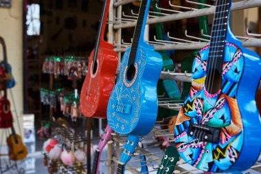 Çeşitli geleneksel Meksika hediyeler satan bir dükkan. El yapımı gitar Meksika pazarında. Renkli küçük gitar ve Hediyelik eşya dükkanları ekranda müzik aletleri. Hatıra Eşyası sanat ve el sanatları.