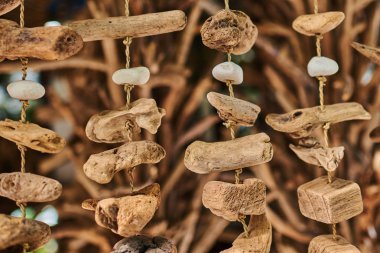 Dalgaların karaya attığı odun parçaları deniz süslemeleri ile yıpranmış. Güzel dekor yapılmış çeşitli doğal ahşap ve taş, arka plan bulanık dükkanı ekranda asılı. El yapımı turizm pazarında.