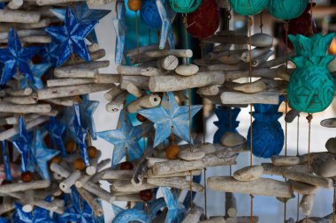 Renkli Hatıra arka plan. Hediyelik eşya dükkanı satan Hediyelik eşya ve el sanatları. El yapımı ahşap mavi oyuncak yıldız mağazada asılı. Desenli Hediyelik eşya ile parlak renkli satışı. Seçici odak.