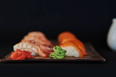 Suşi ahşap tabakta sashimi ayarlayın. Sashimi somon, yılan balığı, ton balığı, avokado, Kraliyet karides, krem peynir havyar tobiko, chuka ile. Sushi Menüsü. Japon yemekleri. Seçici odak. Siyah arka plan.