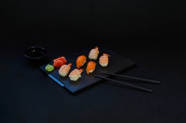 Suşi ahşap tabakta sashimi ayarlayın. Sashimi somon, yılan balığı, ton balığı, avokado, Kraliyet karides, krem peynir havyar tobiko, chuka ile. Sushi Menüsü. Japon yemekleri. Seçici odak. Siyah arka plan.