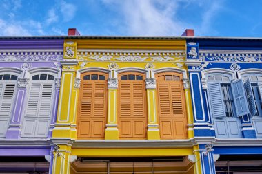 Önden görünüm binanın üst üste cephesinde panjurları birkaç renkli pencere.