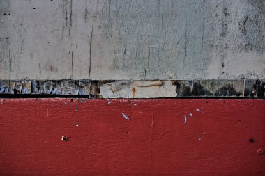 Eski Boyalı yüzeye. Karanlık alçı duvar siyah çizikler ile kirli beyaz ve kırmızı boya ile. Retro aşınmış duvar. Çürümüş kırık kaba soyut afiş yüzey.