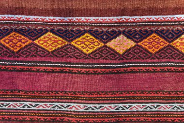 Geometrik desenli halı kapatın. El dokuma halı kırmızı, sarı ve diğer renkler ile. El dokuma halı soyut tasarım ile. Renkli halı. Tekstil arka plan. Arka plan. 