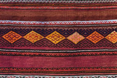 Geometrik desenli halı kapatın. El dokuma halı kırmızı, sarı ve diğer renkler ile. El dokuma halı soyut tasarım ile. Renkli halı. Tekstil arka plan. Arka plan. 