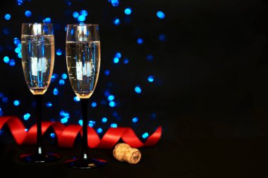 İki bardak şampanya siyah bulanıklık ışıklar arka plan ile. Bir bardak şarap şenlikli bir Noel dekorasyonu. Kutlama, parti ve tatil kavramı. Sığ derinlik-in tarla. Metin için yer.