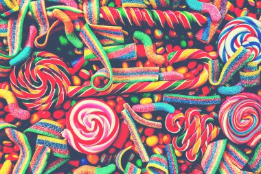 Renkli parlak çeşitli şekerler ve gökkuşağı sarmal lolipop dağınık marmelat, jelibon ve farklı renkli renkli şeker yuvarlak. Üstten görünüm. Şeker arka plan.