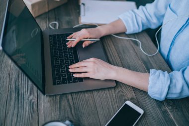 Laptop, ev ofisinde, bilgisayar Internet'e bağlanma kadın serbest meslek otururken net-kitap üzerinde çalışan genç kadın kişi klavye bir kadının el atış görünümü kırpılmış. Yumuşak odak.