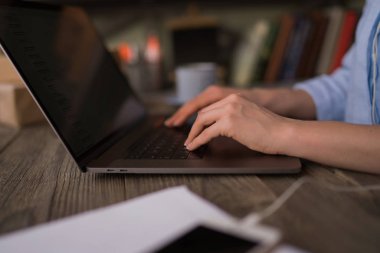 Görünümü yan ve tipik dizüstü klavye üzerinde kadının el kapatın. Kadının elleri verilere erişmeye çalışırken bir dizüstü bilgisayar klavye tuşlarına basarak. Laptop ile evde çalışan erkek. Seçici odak.