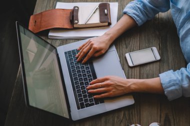Laptop, netbook üzerinde ofis, bilgisayar Internet'e bağlanma kadın serbest meslek otururken çalışan genç kadın kişi klavye bir kadının el atış görünümü kırpılmış. Seçici odak.