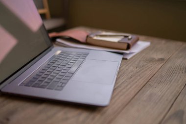 Modern çatı iç ofis resepsiyon ile laptop, defter kahverengi zemin üzerinde. Ahşap masa üstünde açık laptop Close-up. Boş çalışma alanı. Kavramsal çalışma alanı. Arka plan bulanık. Seçici odak.