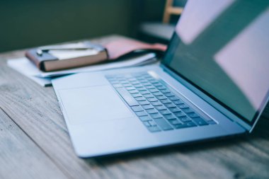 Modern çatı iç ofis resepsiyon ile laptop, defter kahverengi zemin üzerinde. Ahşap masa üstünde açık laptop Close-up. Boş çalışma alanı. Kavramsal çalışma alanı. Arka plan bulanık. Seçici odak.