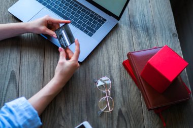 Kredi kartı tutan ve dizüstü bilgisayar kullanarak eller kadın. Online alışveriş. Salonu, alışveriş, satın alma, ödeme, sipariş, ticari kavramı. Online alışveriş ve gold kart kullanarak. Seçici odak.