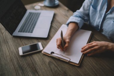 Dizüstü bilgisayar ile çalışma evinde otururken not defterinde yazılı çalışma programı planlama, kadın idari işler müdürü notlar bilgi netbook üzerinde göz. Seçici odak.