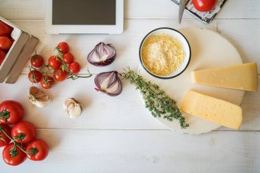 Taze sebze fesleğen ve kesme tahtası beyaz, eski püskü, rustik mutfak masasında peynir. Vintage kırsal mutfak yemek pişirmek için malzemeler. Sağlıklı geleneksel yemekleri. Seçici odak. Boş alan