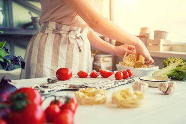 Tanınmayan aşçı, kesme domates ve diğer sebze bıçağı ile ev mutfakta çalışırken kapatın. Kadın yemek salata, Biyo gıda hazırlama. Vejetaryen yiyecekler, sağlık yaşam tarzı kavramı.