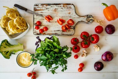Üstten görünüm womam eller. Gıda arka plan. Gıda kavramı. Yemek pişirmek için çeşitli taze malzemeler. Mutfak masasında renkli sebze ile resmi. Dilimlenmiş sebze yemek yapmak için. Seçici odak.