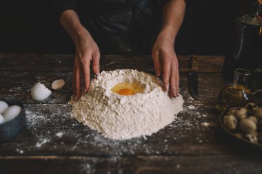 Yemek, yemek ve pişirme kavramı. Eller ekmek hamur yapma. Hamur arka plan. Taze malzemelerle hamur hazırlanması. Rustik bir arka plan üzerinde. Ev yapımı ekmek için malzemeler.