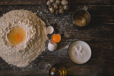 Yemek, yemek ve pişirme kavramı. Hamur un toz bir rustik ahşap zemin üzerine. Çiğ hamur pizza, malzemeler ve mutfak aksesuarları koyu ahşap arka plan üzerinde için.