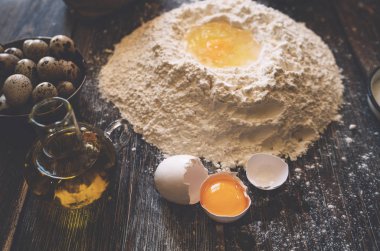 Yemek, yemek ve pişirme kavramı. Hamur için malzemeler. Yumurta, un, oklava ve yumurta kabuğu kahverengi masada. Hamur Hazırlık tarifi ekmek, pizza veya pasta. Pişirme ile çalışma. Yumuşak odak.