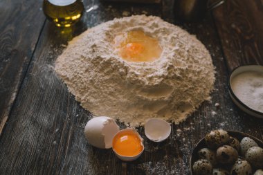 Yemek, yemek ve pişirme kavramı. Hamur un toz bir rustik ahşap zemin üzerine. Çiğ hamur pizza, malzemeler ve mutfak aksesuarları koyu ahşap arka plan üzerinde için.