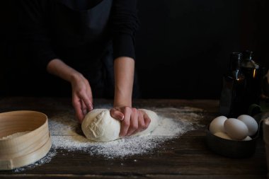 Yemek, yemek ve pişirme kavramı. Eller ekmek hamur yapma. Hamur arka plan. Taze malzemelerle hamur hazırlanması. Rustik bir arka plan üzerinde. Ev yapımı ekmek için malzemeler.