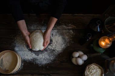 Yemek, yemek ve pişirme kavramı. Eller ekmek hamur yapma. Hamur arka plan. Taze malzemelerle hamur hazırlanması. Rustik bir arka plan üzerinde. Ev yapımı ekmek için malzemeler.