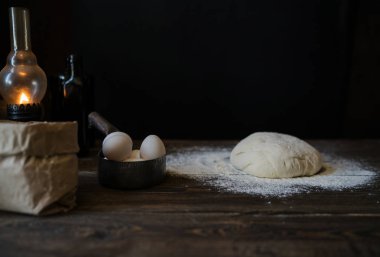 Malzemeler pişirme ahşap masa, yemek pişirmek için hazır yerleştirilir. Yiyecek hazırlama kavramı. Mutfak masasında ekmek veya pizza yemek pişirmek için malzemelerle. Çiğ hamur, un, yumurta üzerinde ahşap masa.