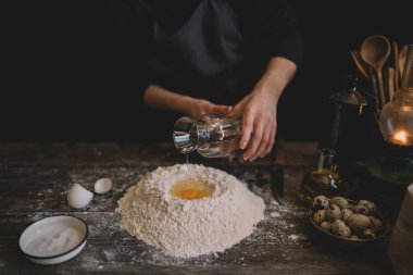 Yemek, yemek ve pişirme kavramı. Eller ekmek hamur yapma. Hamur arka plan. Taze malzemelerle hamur hazırlanması. Rustik bir arka plan üzerinde. Ev yapımı ekmek için malzemeler.