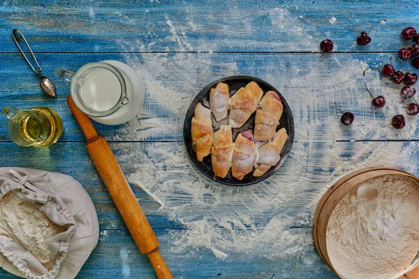 老式木制的桌子上是一个圆形锅的布局的百吉饼带装撒上糖粉 附近樱桃的谎言 — 图库照片