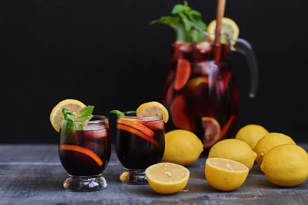 Fruit Drinks Ice Cubes Pitcher Sangria Accompanied Glass Black Table — Stock Photo, Image