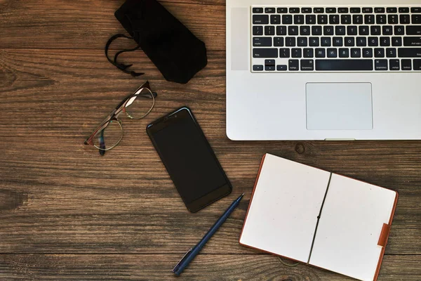 İş kavramı kopya alanı ile. Ofis resepsiyon masası. Çalışma alanı boş not defteri, dizüstü bilgisayar, gözlük smartphone ve kupa vintage ahşap masa üzerinde kahve. Vintage tarzı.