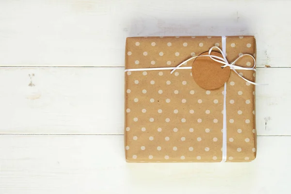 礼品盒包装牛皮纸和白色丝带与标签的文本为圣诞节 情人节 生日或母亲节问候 手工礼品盒在老式的木质背景 度假理念 — 图库照片