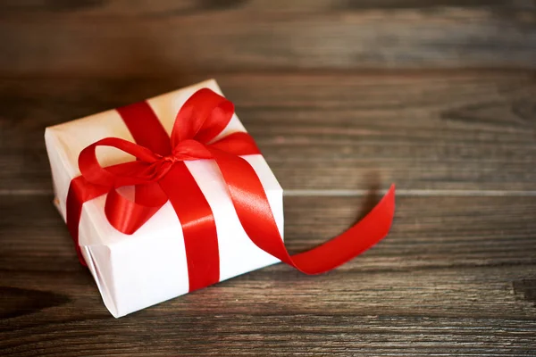 白色手工礼品盒与闪亮的红色缎带在黑暗的木质乡村背景 情人节 生日或新年礼物带为任何节日概念 — 图库照片