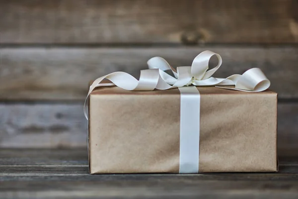手工礼品盒包装工艺纸与白色缎带在灰色的木质乡村背景 情人节 生日或新年礼物带为任何节日概念 — 图库照片