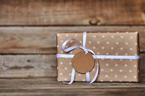 礼品盒包装牛皮纸和白色丝带与标签的文本为圣诞节 情人节 生日或母亲节问候 手工礼品盒在老式的木质背景 度假理念 — 图库照片