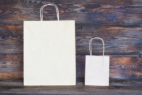 ハンドル付き茶色のクラフト ペーパー パッケージ ロゴやデザイン 食品配送 消費者と広告の概念で木の板のための領域を空のショッピング バッグのモックアップ — ストック写真