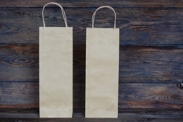 消費者と広告のコンセプト ヴィンテージの木製ボードの背景に空白の茶色の紙袋 ハンドル ロゴやデザインの領域に空白クラフト ショッピング バッグと紙袋 — ストック写真