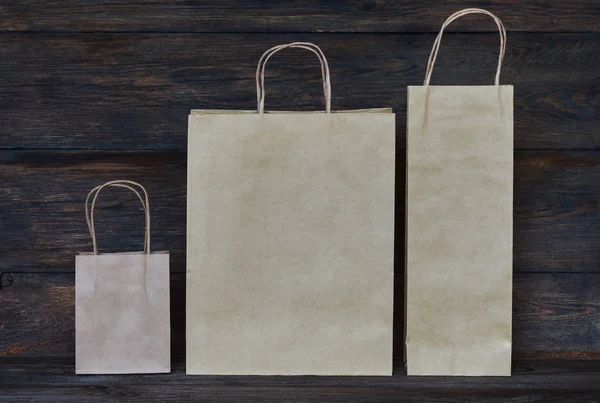 ハンドル付き茶色のクラフト ペーパー パッケージ ロゴやデザイン 食品配送 消費者と広告の概念で木の板のための領域を空のショッピング バッグのモックアップ — ストック写真