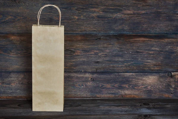 Sale, consumerism and advertisement concept -  blank  brown paper  bags on the vintage wooden board background. Paper bags with handles, blank craft shopping bag with area for your logo or design.