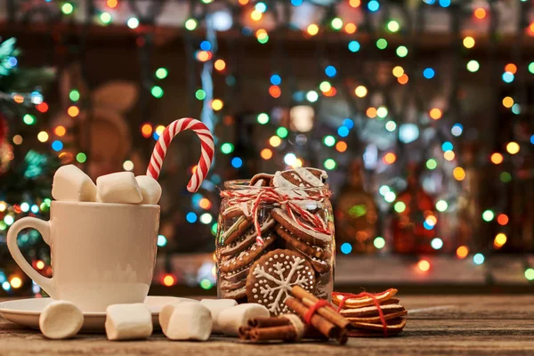 Kahve ile bir Noel ışık arka plan üzerine tarçın ve kurutulmuş portakal.