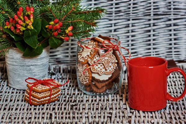 A stack of four cookies with red cup of coffee. Gingerbread  handcrafted  tied a red ribbon.