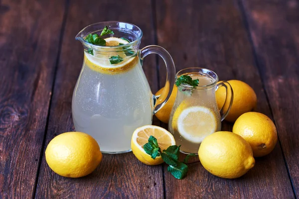 Limonata sürahi buz ile. Limon ve cam yakınındaki bir yarım limon.