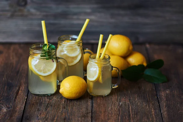 Nane ve buz ile ev yapımı limonata. Mason limonata rustik ahşap arka plan üzerinde kavanozları. Lezzetli ve sulu limonata, yararlı vitaminler ve antioksidanlar dolu. Sağlıklı ve detoks yaz içeceği.