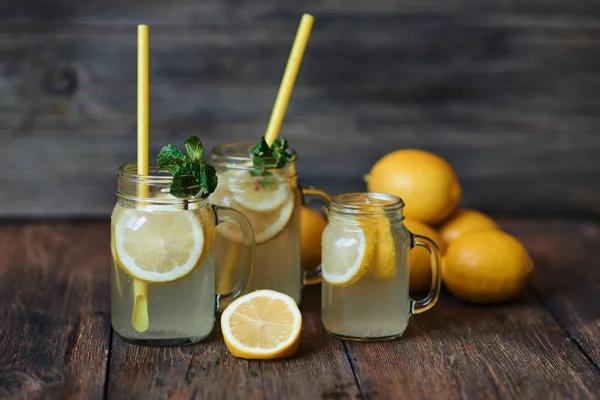 Nane ve buz ile ev yapımı limonata. Mason limonata rustik ahşap arka plan üzerinde kavanozları. Lezzetli ve sulu limonata, yararlı vitaminler ve antioksidanlar dolu. Sağlıklı ve detoks yaz içeceği.