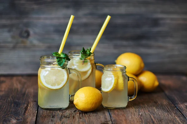 Nane ve buz ile ev yapımı limonata. Mason limonata rustik ahşap arka plan üzerinde kavanozları. Lezzetli ve sulu limonata, yararlı vitaminler ve antioksidanlar dolu. Sağlıklı ve detoks yaz içeceği.