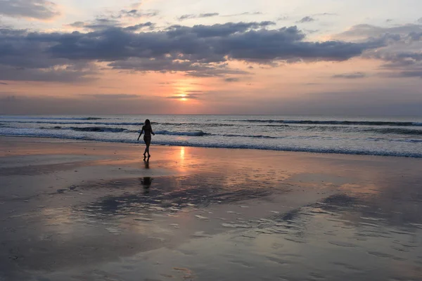 Gökyüzü ve deniz. Güzel gün batımı. Kız okyanus sahilde yürüyüş silüeti. Günbatımı parlak gökyüzü okyanus üzerinde genç kadın tatil sırasında doğanın güzelliği sahiptir. Mutlu ücretsiz yaşam kavramı.