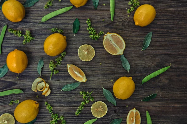 Dilimlenmiş ve limon meyve ile bütün bir model kahverengi ahşap arka plan üzerinde bırakır.