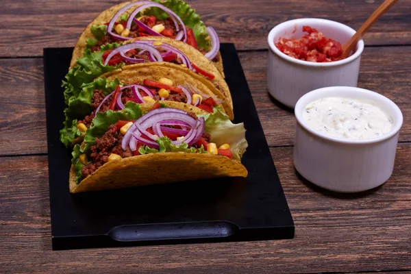 Tavuk eti, kırmızı domates ve lezzetli salsa ve ekşi krema sos ile Mor Soğan kesme parçaları ile ulusal baharatlı yemek closeup görüntü