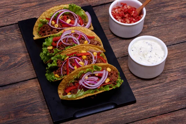 Baharatlı domates salsa ve ekşi krema sos yemek için hazır ile sıcak geleneksel yemek hazır. Kaç taco doğal madde bölümlerini